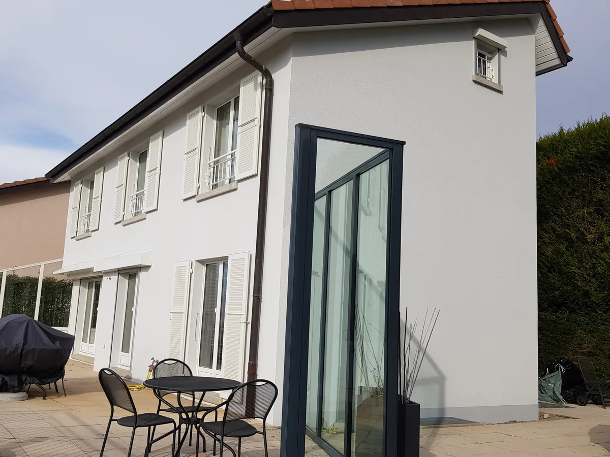 Façade claire avec volets blancs et éléments vitrés