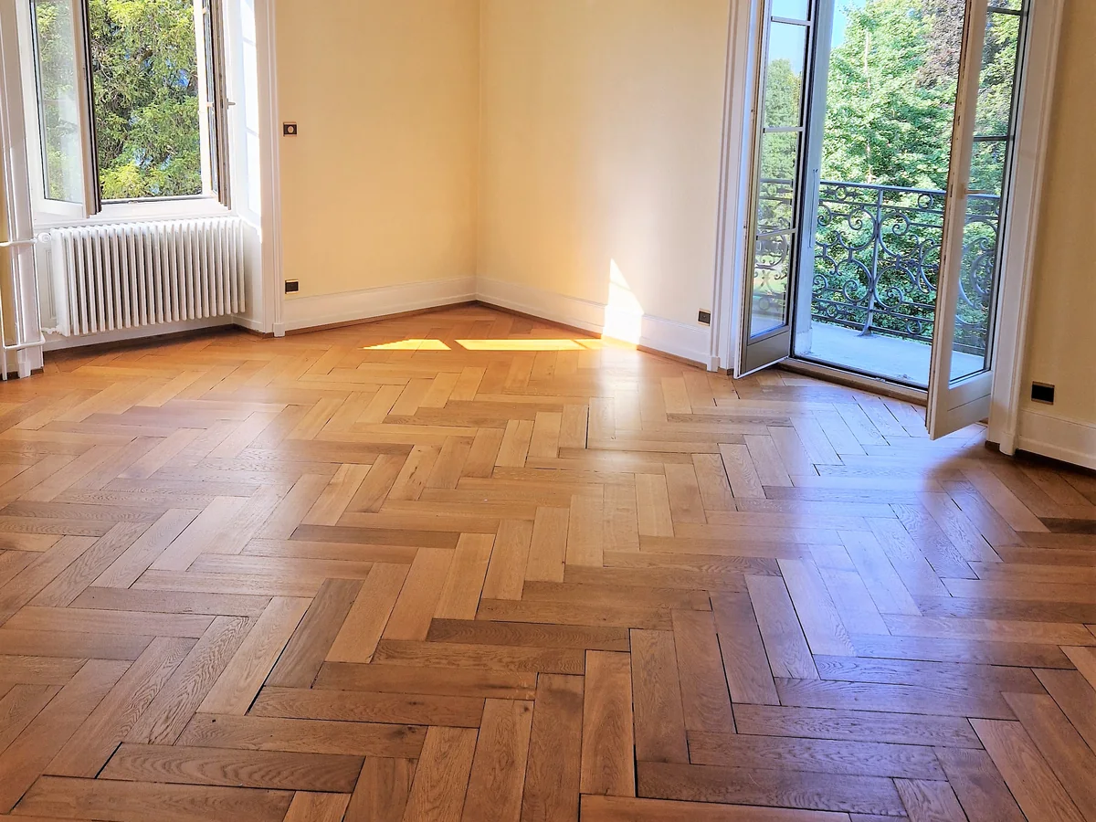 Parquet à motifs dans une pièce lumineuse ouverte sur un balcon