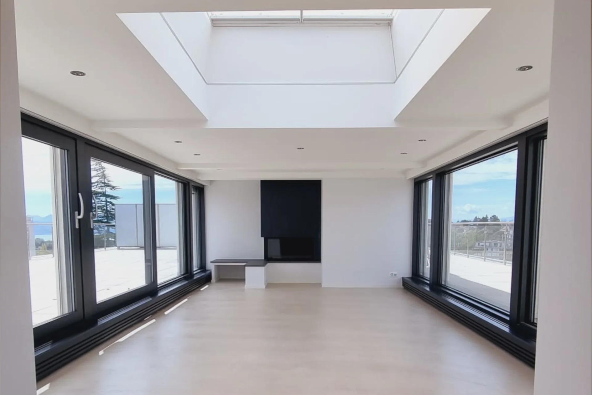 Séjour rénové avec de grandes baies vitrées, un plafond clair et une cheminée